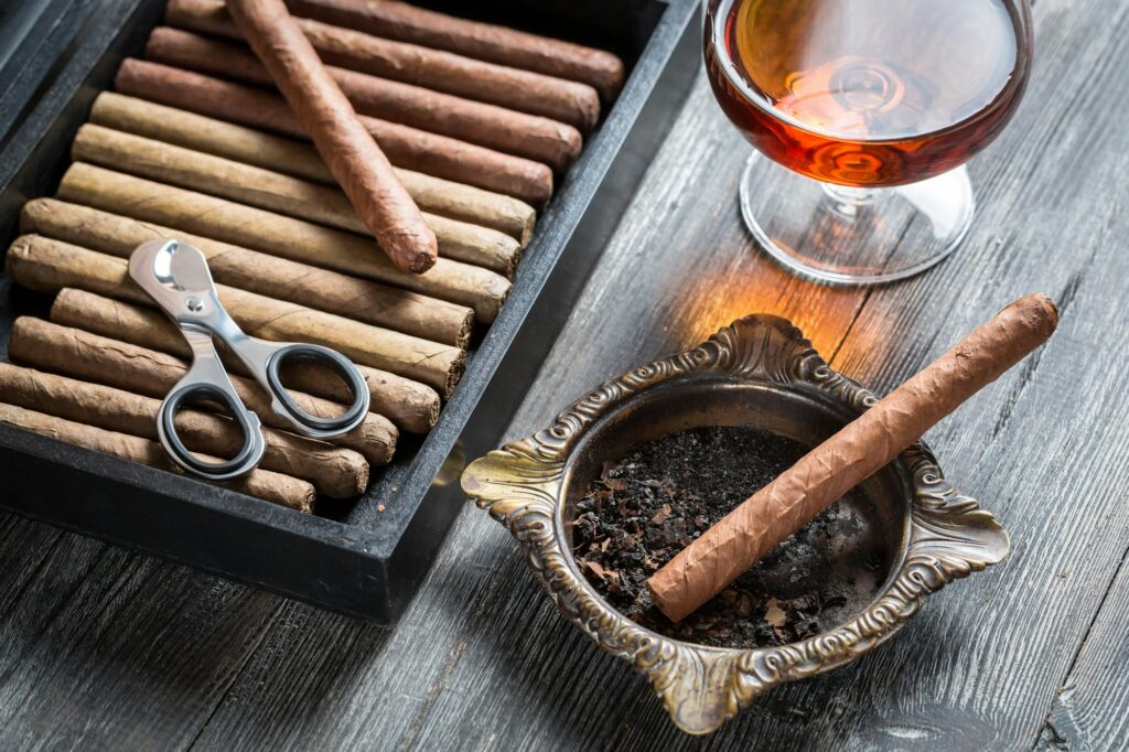 Cigar in ashtray and cognac